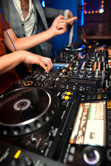 Dj mixes the track in the nightclub at party. In the background laser light show