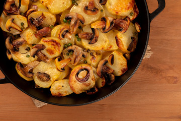 Wall Mural - A closeup photo of a braiser with cooked vegetables, potato, green peas, mushrooms, shot from the top on a dark rustic background with a place for text, a vegan dinner