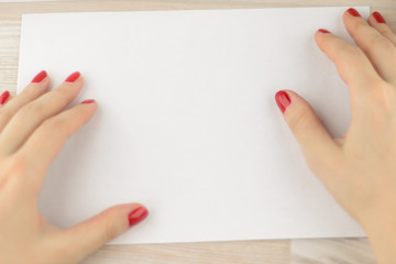 Wall Mural - neat office work: Young worker with painted nails gently smoothes the envelope for further work