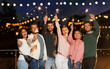 © Syda Productions - leisure, celebration and people concept - happy friends with sparklers at rooftop party at night with blurred bokeh lights
