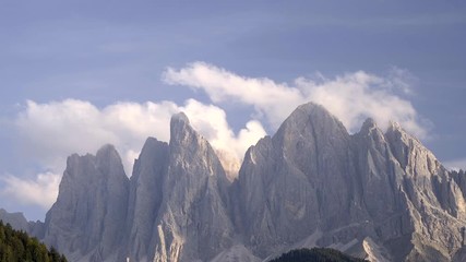 Wall Mural - Clouds passing over rocky peaks in Italian Dolomites near Santa Maddalena village in Val di Funes Valley, Italy.