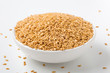 Golden flaxseed in bowl on white background