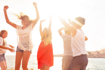 Wall Mural - Happy friends dancing outdoors in summer