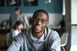 © fizkes - Portrait of smiling African American student looking at camera sitting in cafe, black millennial man posing making picture in coffeeshop, afro male in glasses drinking coffee working in coffeehouse