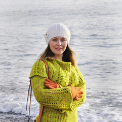 Girl in autumn clothes on the background of the sea