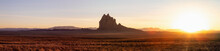 Striking Panoramic Landscape View Of A Dry Desert With A Mountain Peak In The Background During A Vibrant Sunset. Taken At Shiprock, New Mexico, United States.