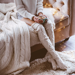 Poster - Girl drinking warm cocoa on a sofa