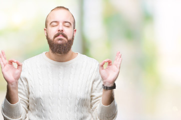 Sticker - Young caucasian hipster man wearing winter sweater over isolated background relax and smiling with eyes closed doing meditation gesture with fingers. Yoga concept.