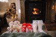 © Adrian Cotiga/Stocksy - Feet in woollen socks by the Christmas fireplace.