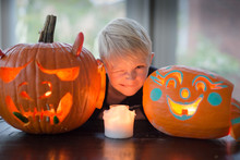 Boy Makes A Funny Face Next To His Halloween Jack-o-lanterns
