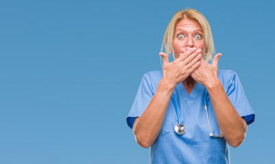 Sticker - Middle age blonde nurse surgeon doctor woman over isolated background shocked covering mouth with hands for mistake. Secret concept.