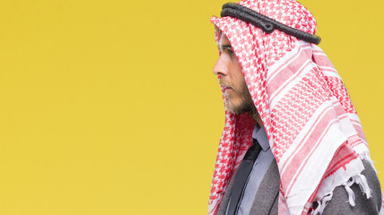 Sticker - Young handsome arabian man with long hair wearing keffiyeh over isolated background looking to side, relax profile pose with natural face with confident smile.