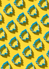 Blue Christmas Tree-shaped Cookie Cutters On Yellow Background. Complementary Colors.