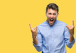 © Krakenimages.com - Young handsome man over isolated background shouting with crazy expression doing rock symbol with hands up. Music star. Heavy concept.