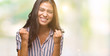 © Krakenimages.com - Young beautiful arab woman over isolated background very happy and excited doing winner gesture with arms raised, smiling and screaming for success. Celebration concept.