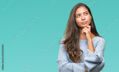 Fotografía Young beautiful arab woman wearing winter sweater over isolated background with hand on chin thinking about question, pensive expression
