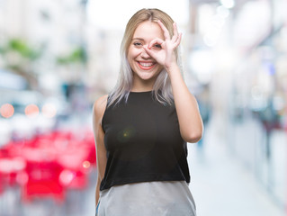 Sticker - Young blonde woman over isolated background doing ok gesture with hand smiling, eye looking through fingers with happy face.