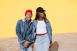 © BONNINSTUDIO/Stocksy - Portrait of cool couple wearing denim clothes in yellow wall.