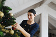 © michela ravasio/Stocksy - Woman decorating Christmas tree with balls