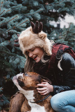 A Woman In Her Twenties Poses With Her English Bulldog In The Snow