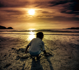 Wall Mural - Girl digging in sand, outdoor with sunlight. Concept of connecting children with nature.