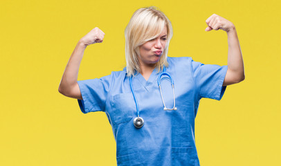 Young beautiful blonde doctor woman wearing medical uniform over isolated background showing arms muscles smiling proud. Fitness concept.