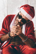 © Andrey Pavlov/Stocksy - Santa lighting a cigarette
