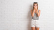 © Krakenimages.com - Young beautiful blonde woman over white brick wall shocked covering mouth with hands for mistake. Secret concept.