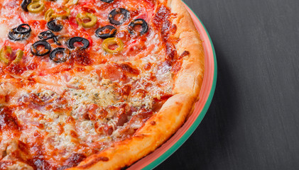 Canvas Print - Mixed pizza Italian food with chicken, tomatoes, mushrooms, ham, salami, olive and cheese on dark wooden background. Homemade pizza.