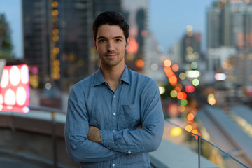 Wall Mural - Portrait of young handsome man outdoors at night in city