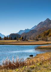 Poster - mountain and lake landscape with idyllic alpine village in colorful golden fall colors