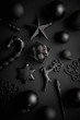 Christmas minimalistic and simple composition in mat black color. Christmas gifts, decorations on black background. Flat lay, top view .