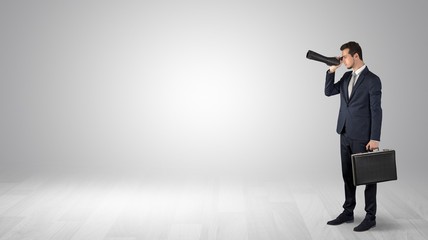 Wall Mural - businessman looking forward with binoculars in an empty space