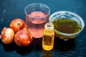 Close up of caster oil,onion juice mixture used to make hair stronger and thicker on wooden surface.;