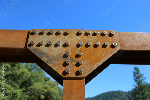 Fotografie, Obraz rusted steel connection with bolts with blue sky background
