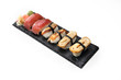 Zestaw sushi. Kawałki sushi nigiri  na kamiennym czarnym talerzu