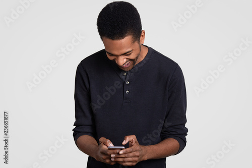 Overjoyed Dark Skinned Man With Afro Haircut Laughs Happily