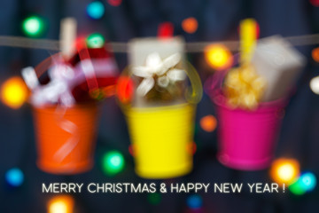 Wall Mural - gifts boxes in buckets of colored garlands on lights background. Merry Christmas and Happy New Year card 