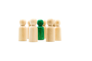 Wall Mural - Green figure standing out from the crowd inside circle of wooden figures, isolated on white background