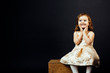 © Carlos David - Portrait of a smiling toddler girl looking sideways with a look of excitement, isolated on black studio background