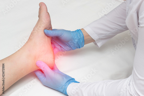 Fotomural Doctor examines the leg of the woman’s heel for heel spurs, pain in the foot, pl