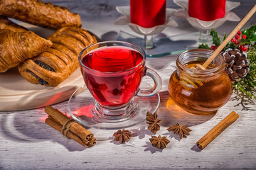 Wall Mural - Traditional Christmas apple punch with cinnamon and honey on a table of candles on a light background