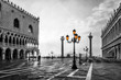 Black and white photo of San Marco square in Venice at sunrise with Doge's Palace, Palazzo Ducale and Saint Mark Column