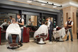 © serhiibobyk - View from back of barbers servicing clients in barber shop