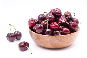 Ripe sweet cherry in wooden bowl isolated on white background.