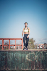 Wall Mural - Pretty woman performs exercising outdoors in the park.