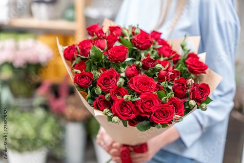 bouquet in the hands of a cute girl. garden red spray roses. Color passionately scarlet, Autumn mood © malkovkosta