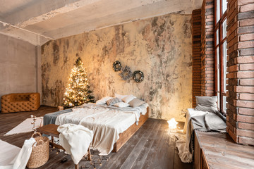 Wall Mural - Loft style apartments. Bed in the bedroom, high large Windows. Brick wall with candles and Christmas tree. warm and brown color