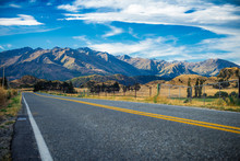 New Zealand Yellow Highway Lines Converging Into The Distance With No Recognizable People Or Buildings Under A Polarised Blue Sky Horizon & Mountain Range Somewhere Between Iconic Wanaka & Queenstown 