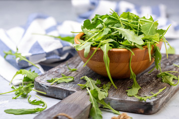 Wall Mural - Arugula leaves for salad in a wooden bowl.